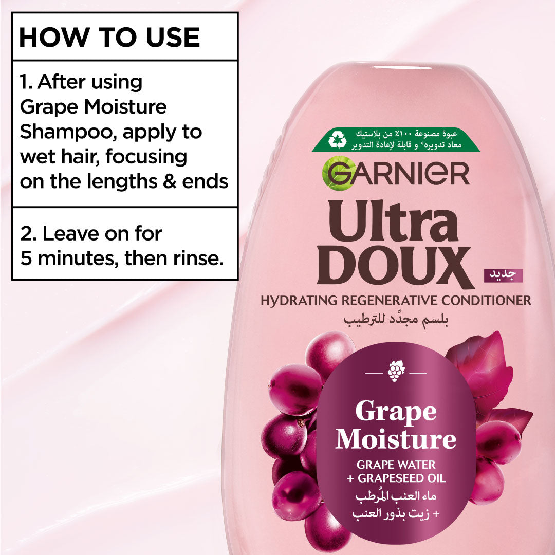 Garnier Ultra Doux Grape Moisture conditioner bottle with usage instructions on a pink background