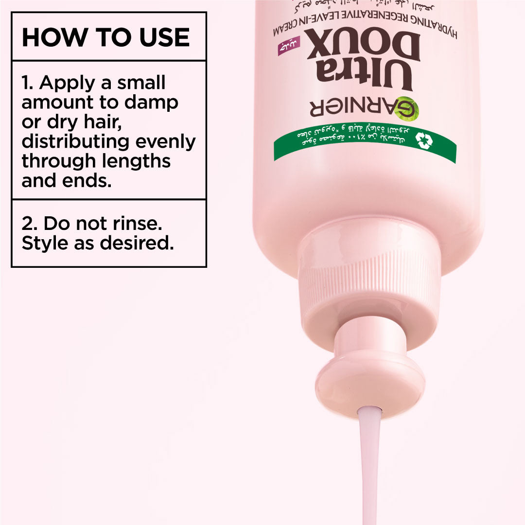 Pink bottle of Garnier Ultra Doux hair product with usage instructions on a white background